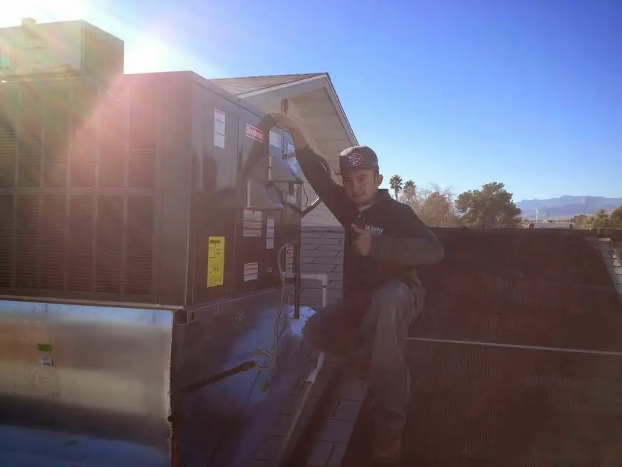 HVAC technician performing HVAC Inspection on a rooftop unit in Oshkosh